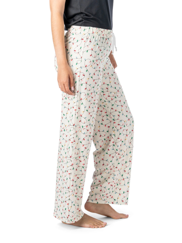 christmas lights pattern pajama pants worn by a person on a white background