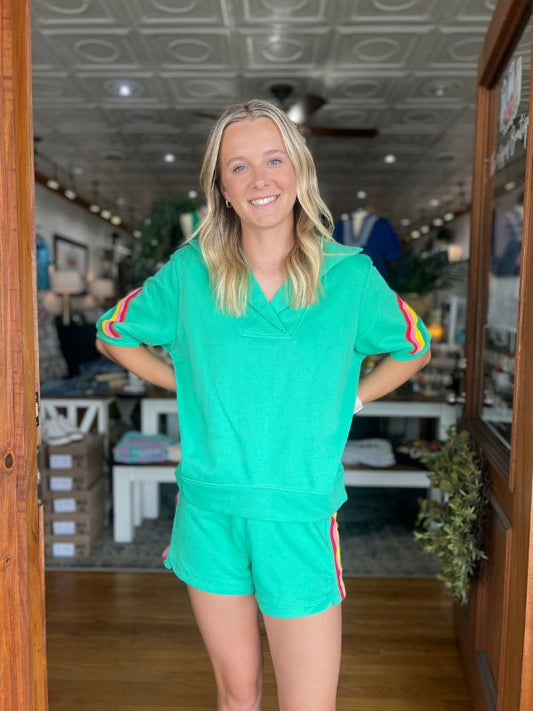 Woman wearing a green sports outfit with colorful accents in an indoor setting.