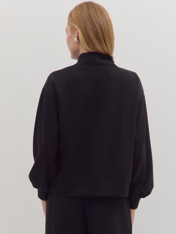 Person wearing a black outfit on a light gray background