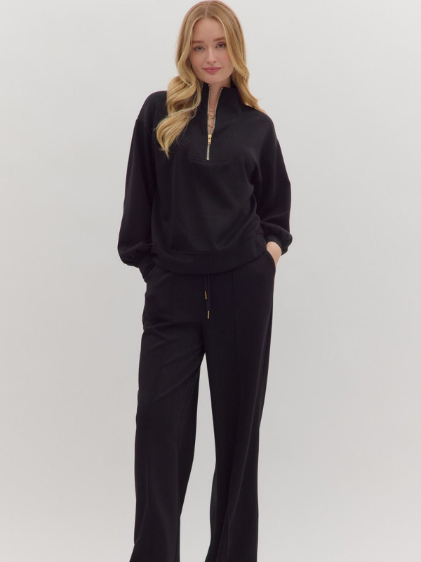 Woman wearing a black outfit on a plain background
