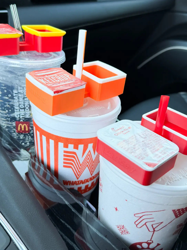Car cup holder with multiple drinks including McDonald's and Wendy's branded cups.