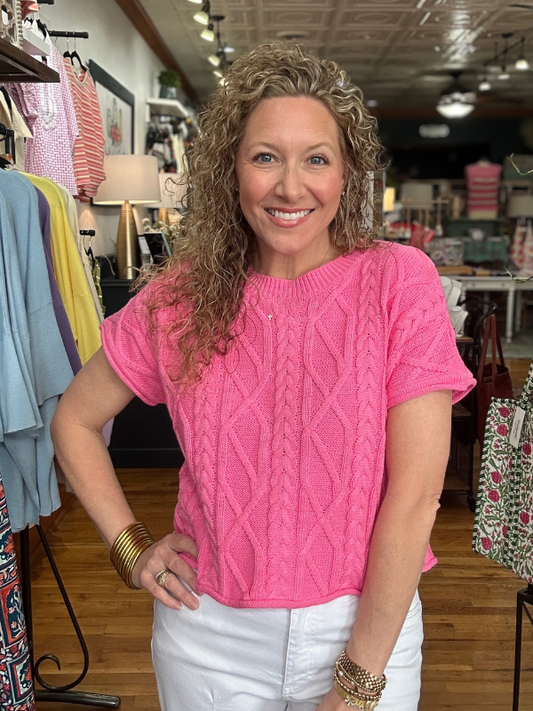 Woman wearing a pink sweater in a clothing store