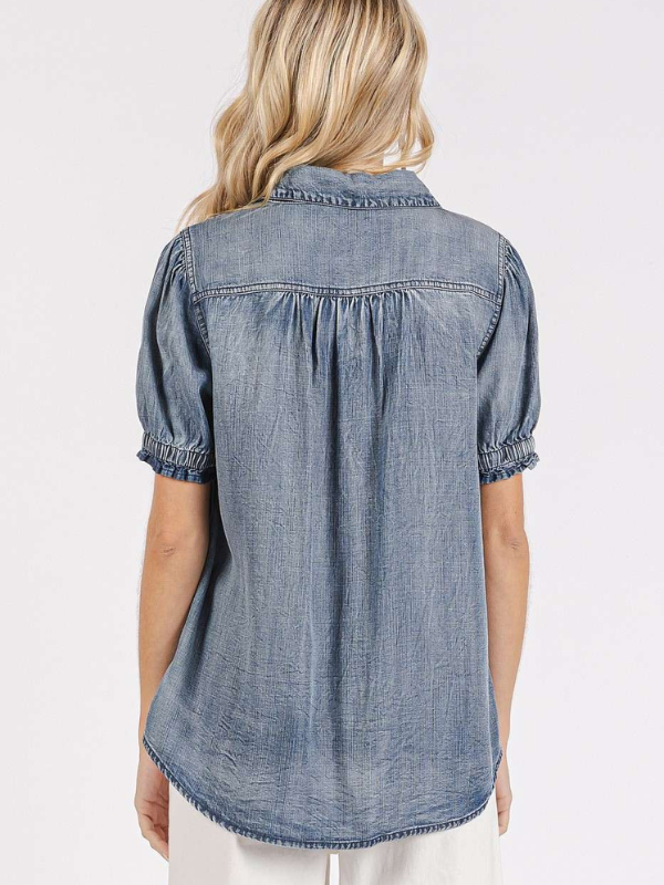 Denim shirt worn by a person on a white background