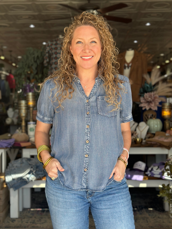 Woman wearing a denim shirt and jeans in a store setting