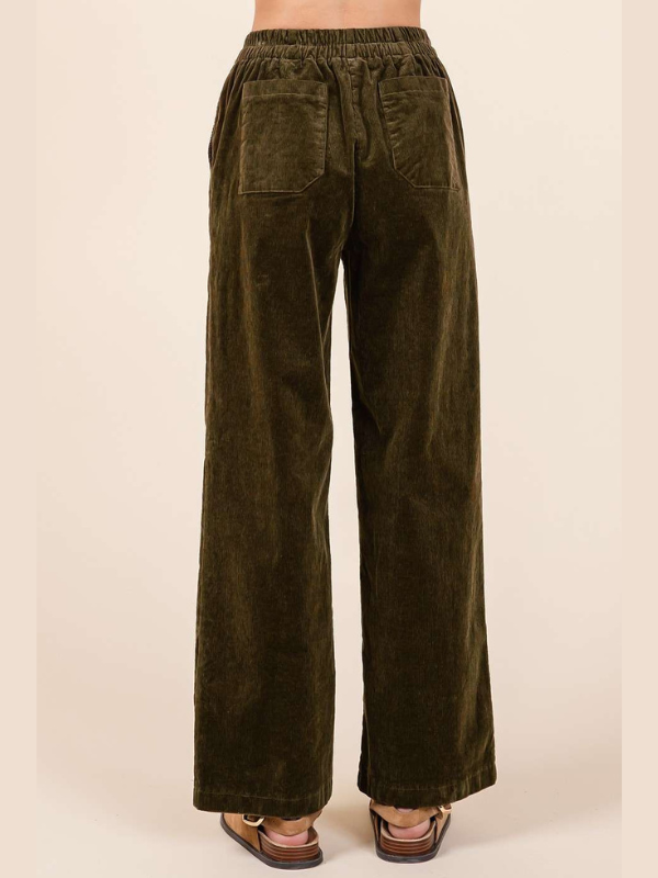 Olive green corduroy pants on a beige background
