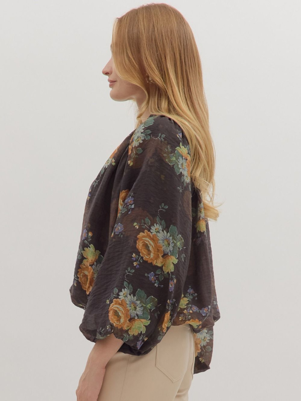 Woman wearing a floral kimono-style garment against a plain background