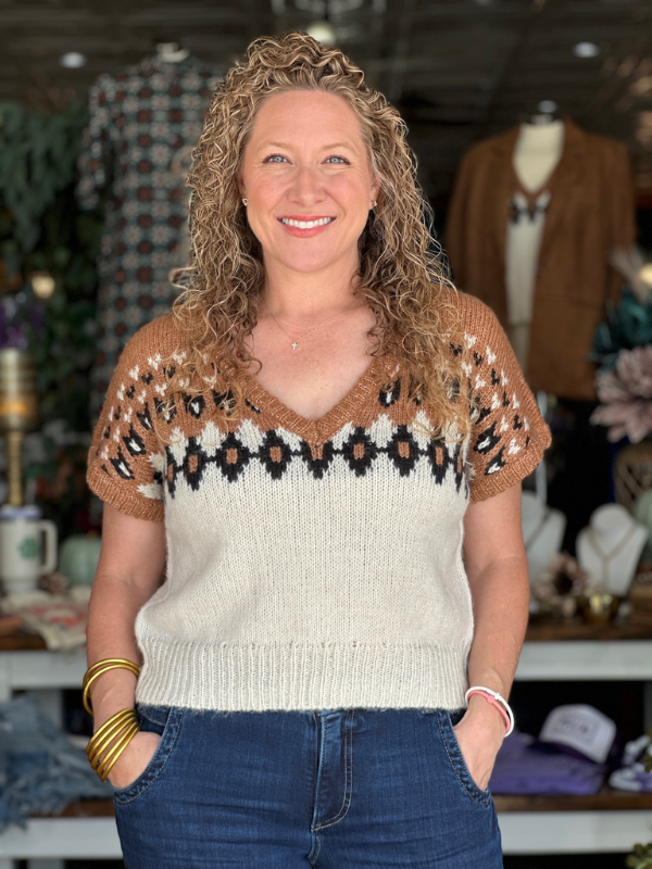 Woman wearing a patterned sweater in a store setting