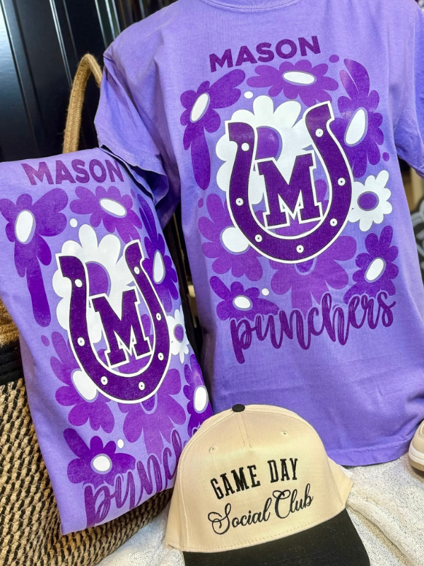 Purple t-shirt with floral design and 'Mason Punchers' text, next to a matching pouch and beige cap with 'Game Day Social Club' text.