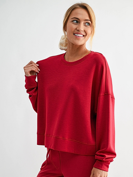 Woman wearing a red sweatshirt and pants on a white background