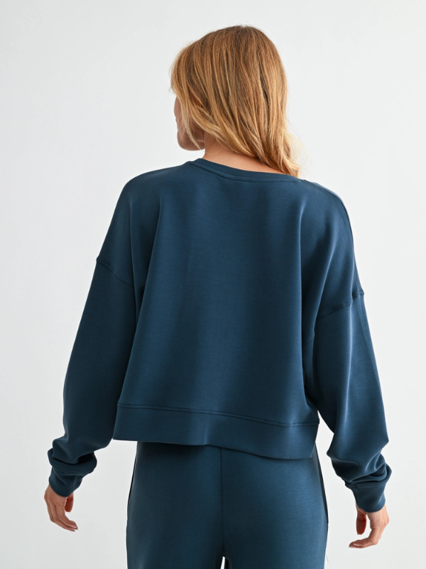 Person wearing a blue sweatshirt and pants on a white background