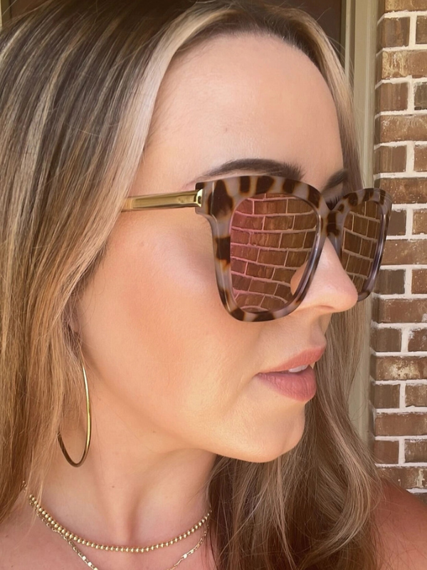woman wearing sunglasses with pink lenses and tortoise frames