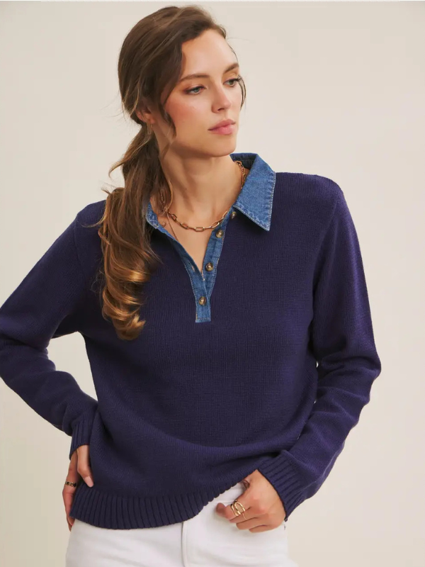 Woman wearing a navy sweater with a denim collar against a neutral background