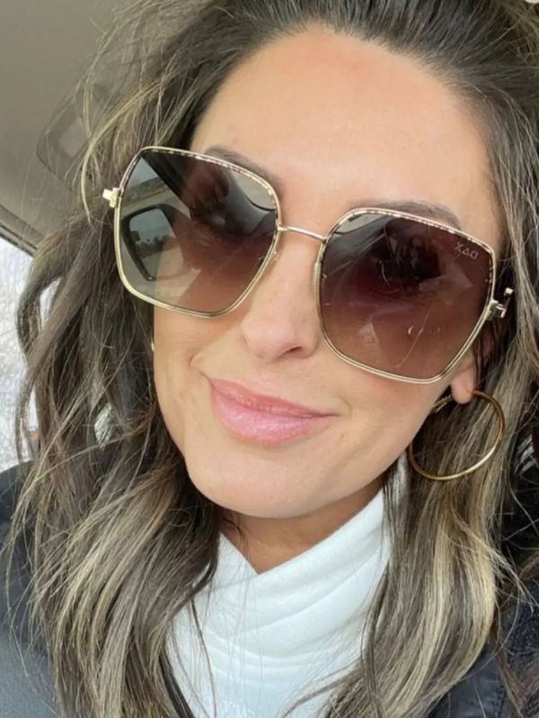 Person wearing large sunglasses with a neutral background