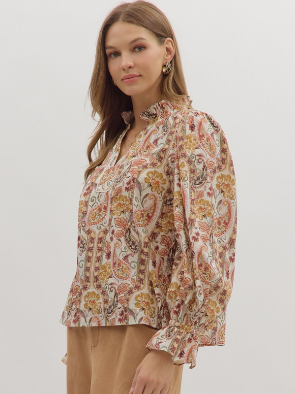 Woman wearing a floral blouse with long sleeves on a plain background
