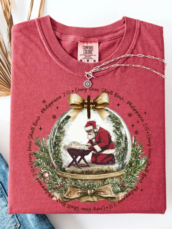 Red shirt with Christmas-themed design featuring Santa Claus in a snow globe.