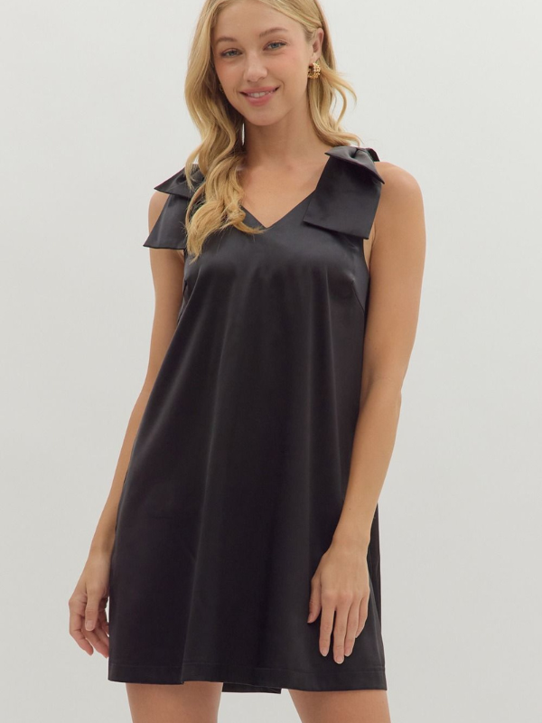Woman wearing a black dress with a collar against a plain background
