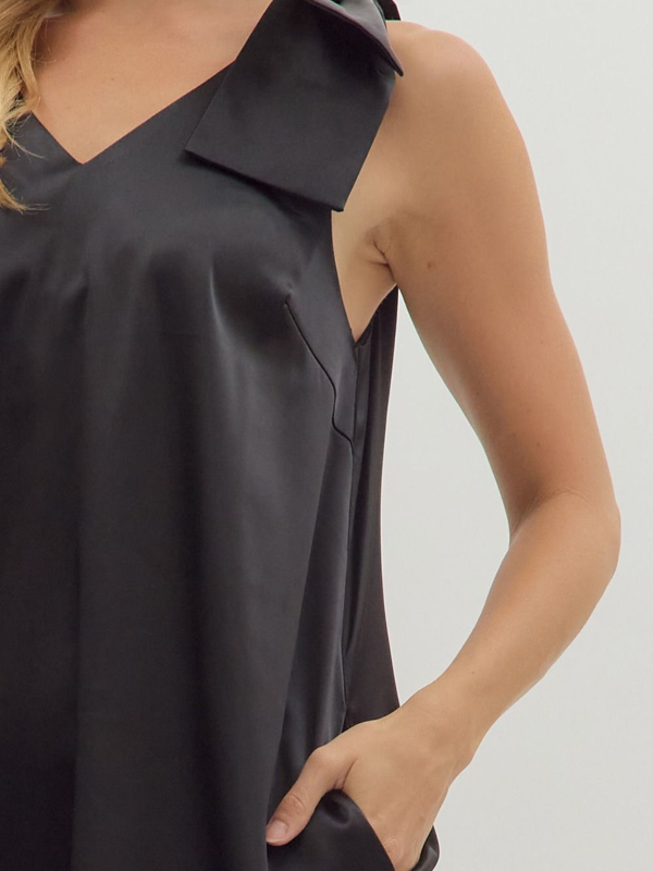 Black sleeveless top worn by a person on a plain background