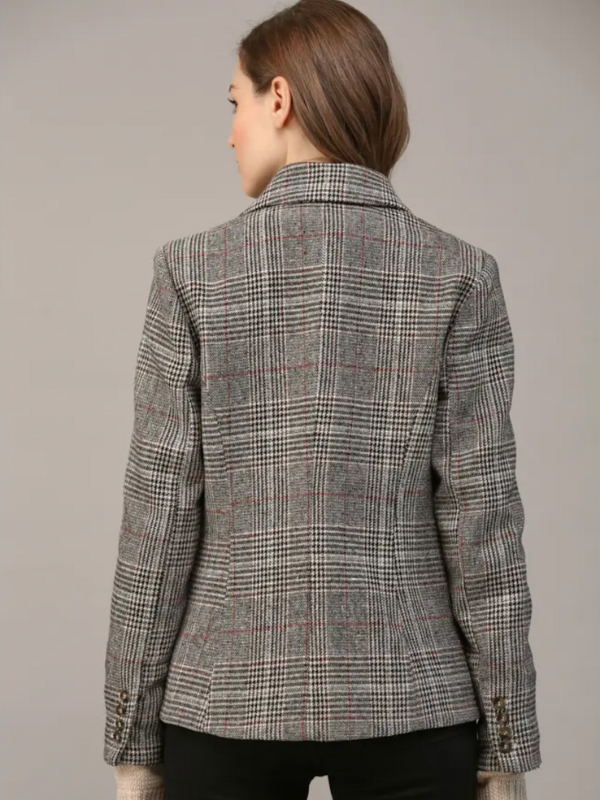 Person wearing a plaid blazer against a plain background
