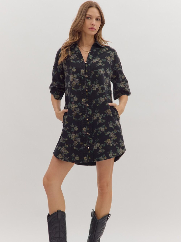 Woman wearing a black floral dress with black boots on a white background