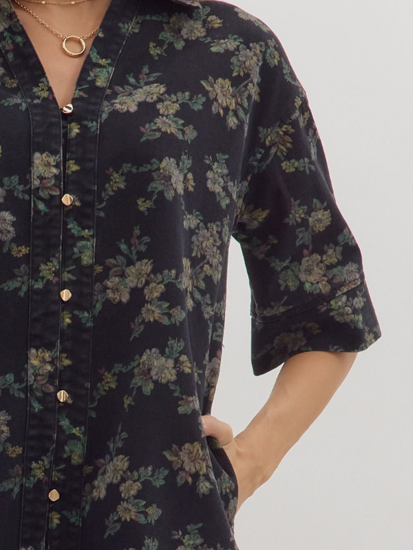 Black floral patterned shirt worn by a person on a white background
