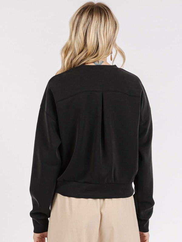 Person wearing a black jacket on a plain background