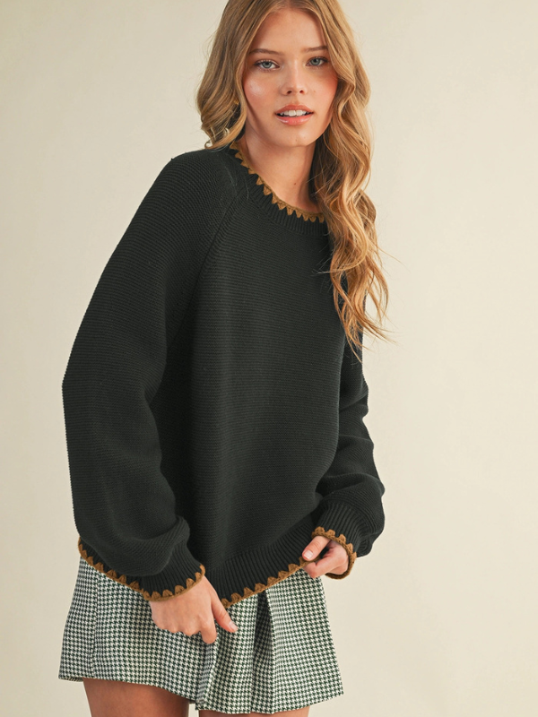 woman wearing a black sweater with mocha stitching