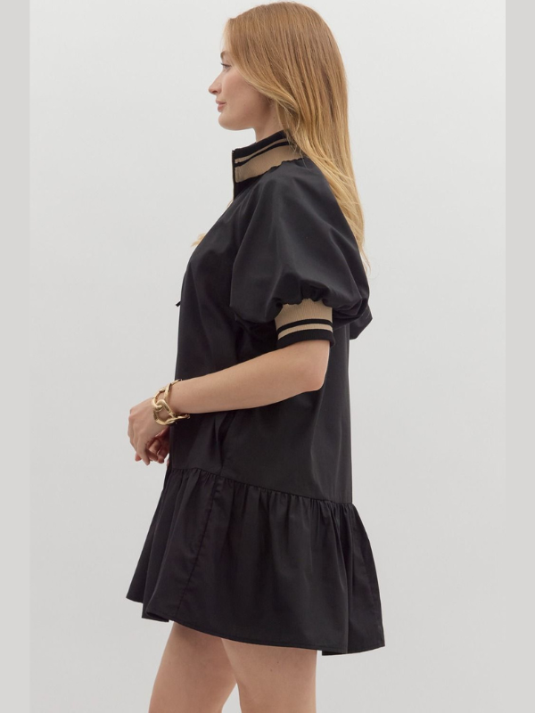Woman wearing a black dress with striped cuffs on a white background