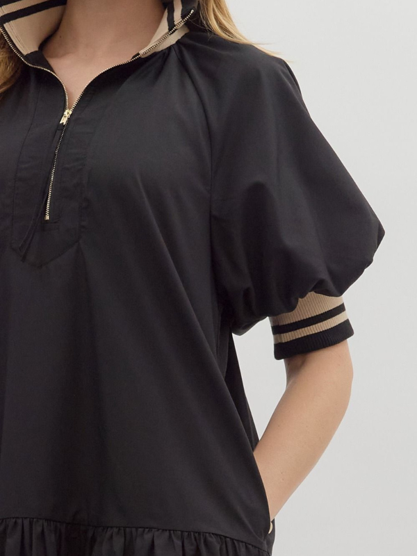 Black dress with beige accents on a plain background