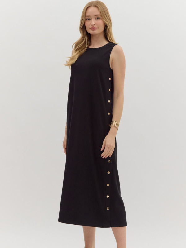 Woman wearing a black dress with gold buttons on a white background