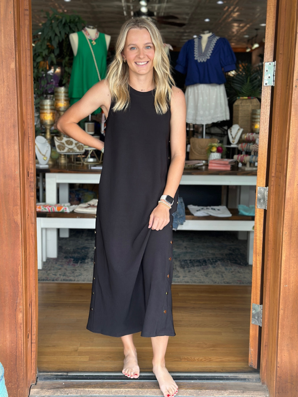 Woman in a black dress standing in a store doorway