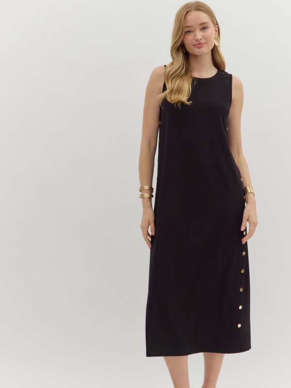 Woman wearing a black sleeveless dress with button details on a white background