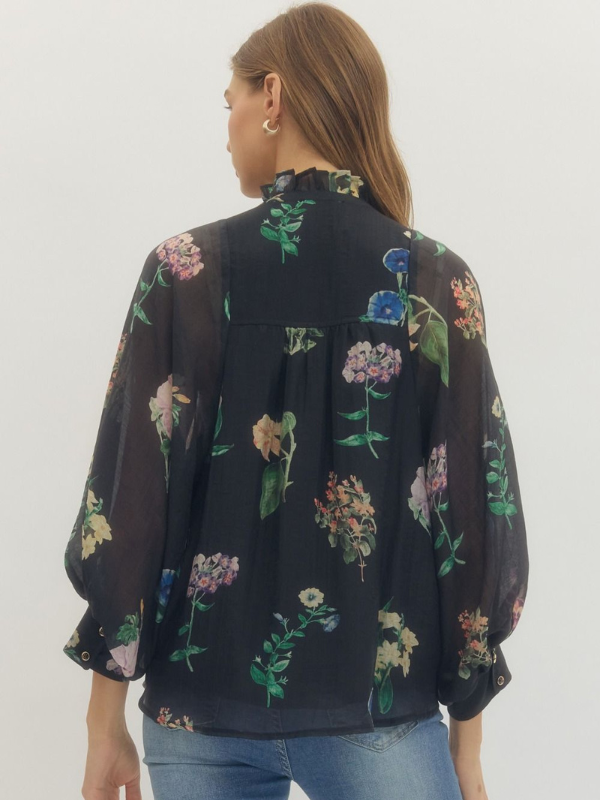 Woman wearing a black floral blouse against a white background