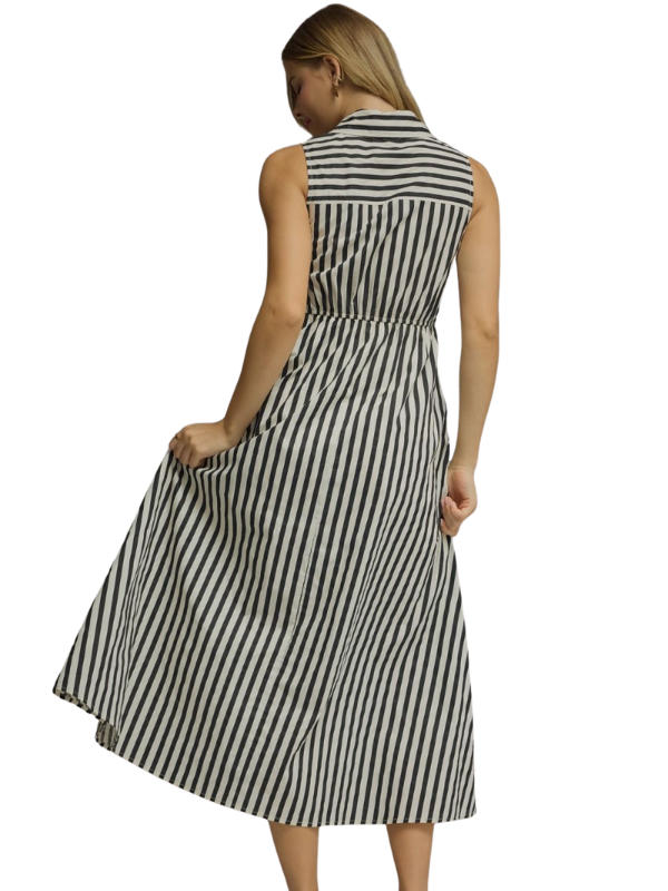 A woman shown from the back wearing a sleeveless midi dress with vertical black and white stripes, set against a plain white background.