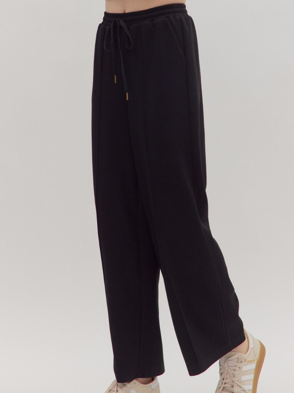 Black wide-leg pants worn by a person on a plain background