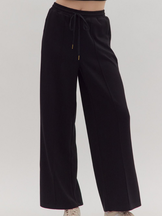 Black wide-leg pants on a plain background