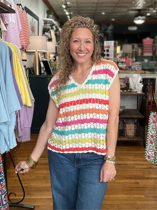 Woman wearing a colorful striped sleeveless top in a store setting