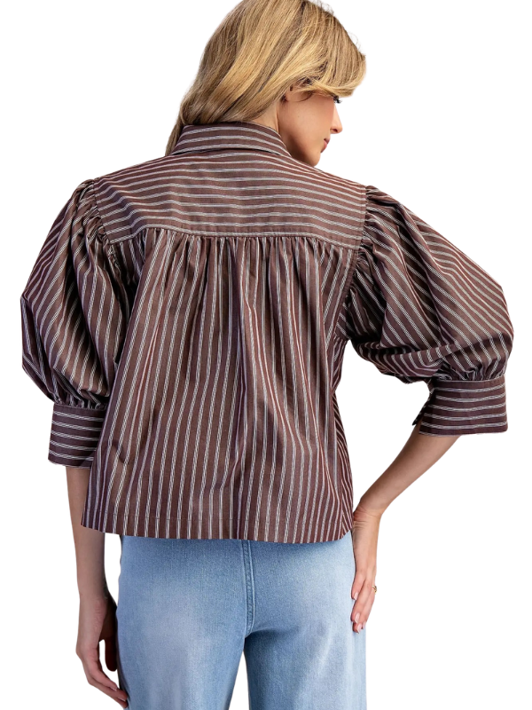 woman wearing a brown and cream striped collared top with jeans