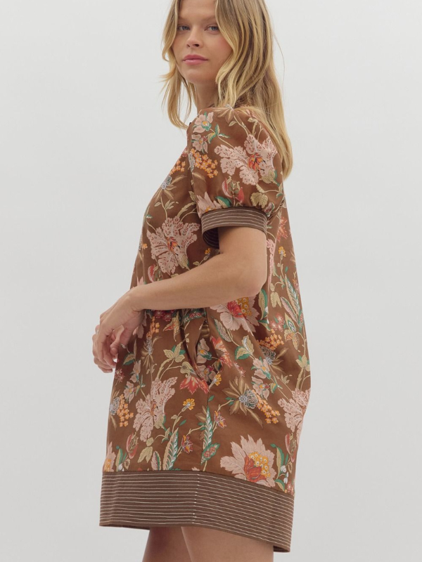 Woman wearing a brown floral dress on a white background