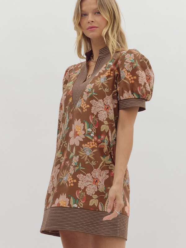 Woman wearing a brown floral dress on a white background