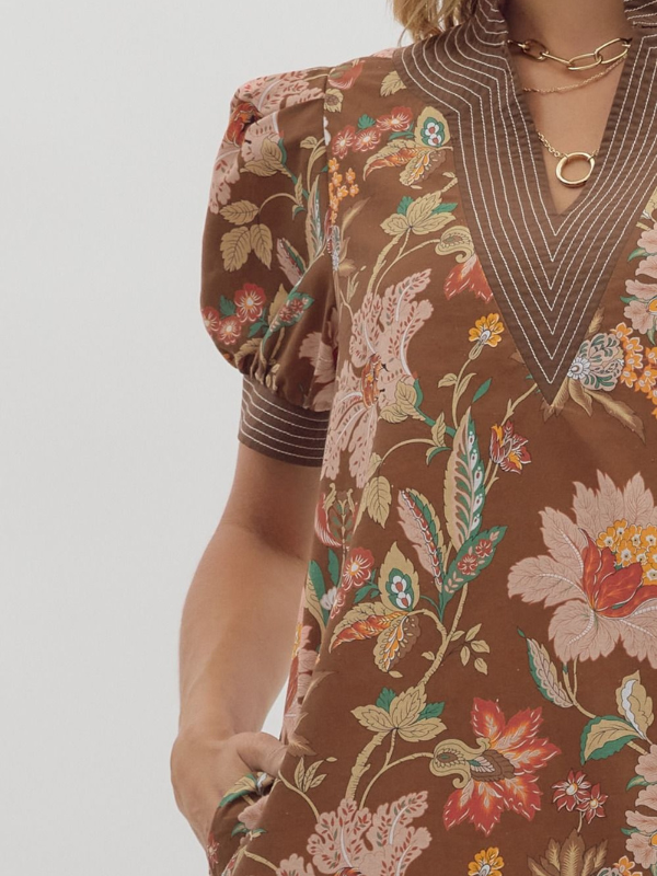 Close-up of a person wearing a brown floral dress