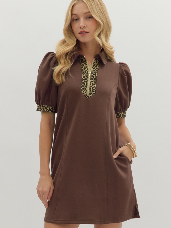 Woman wearing a brown dress with leopard print details on a white background