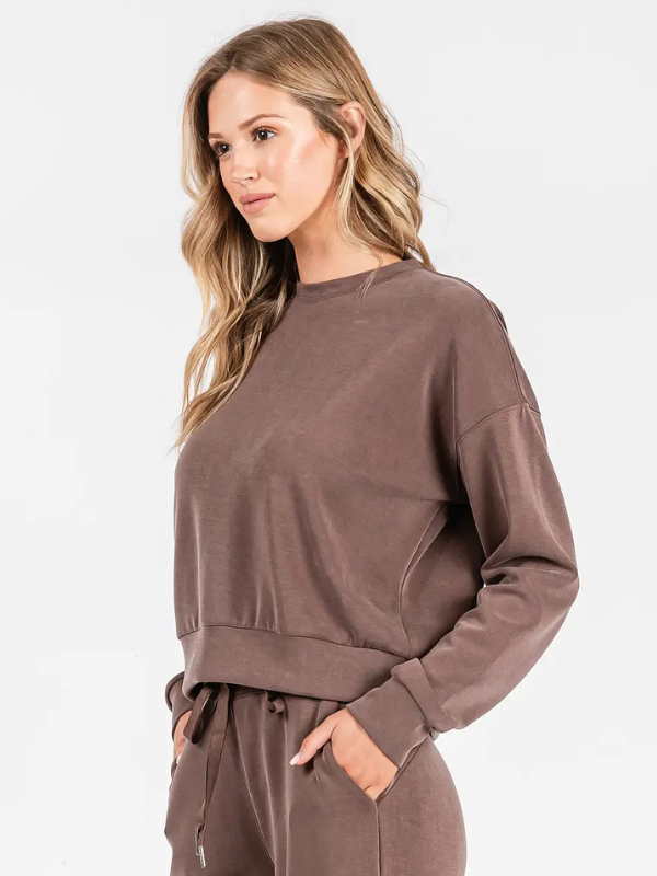 Woman wearing a brown sweatshirt on a white background