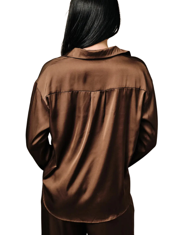 A person shown from the back wearing a brown satin or silky long-sleeve top and matching bottoms against a plain white background.