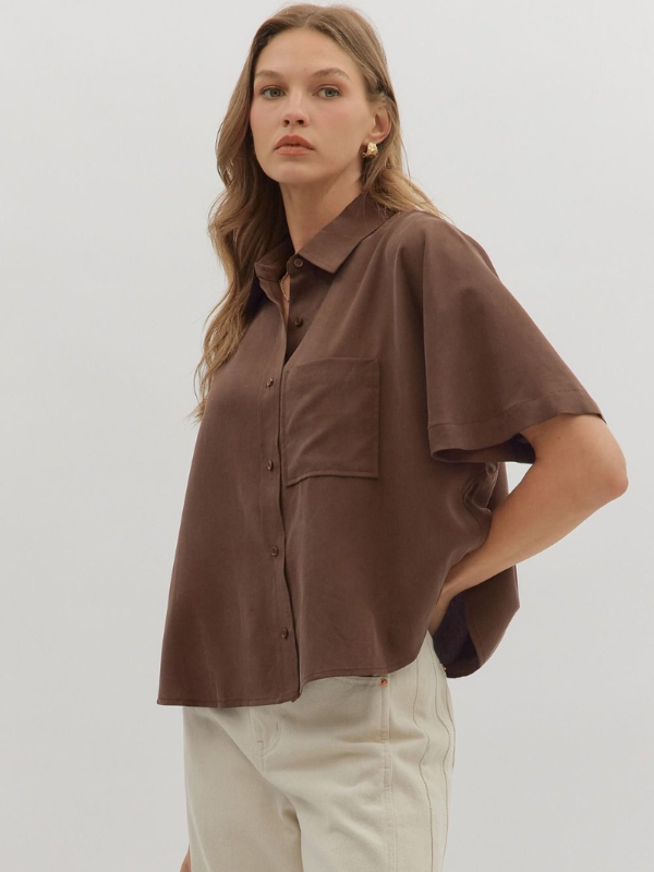 Woman wearing a brown shirt with a neutral background