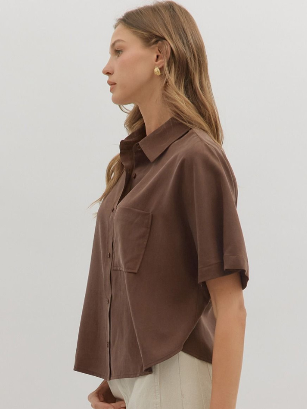 Woman wearing a brown shirt with a neutral background