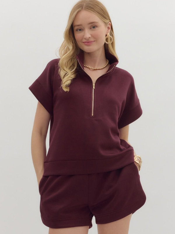 Woman wearing a burgundy outfit with a white background
