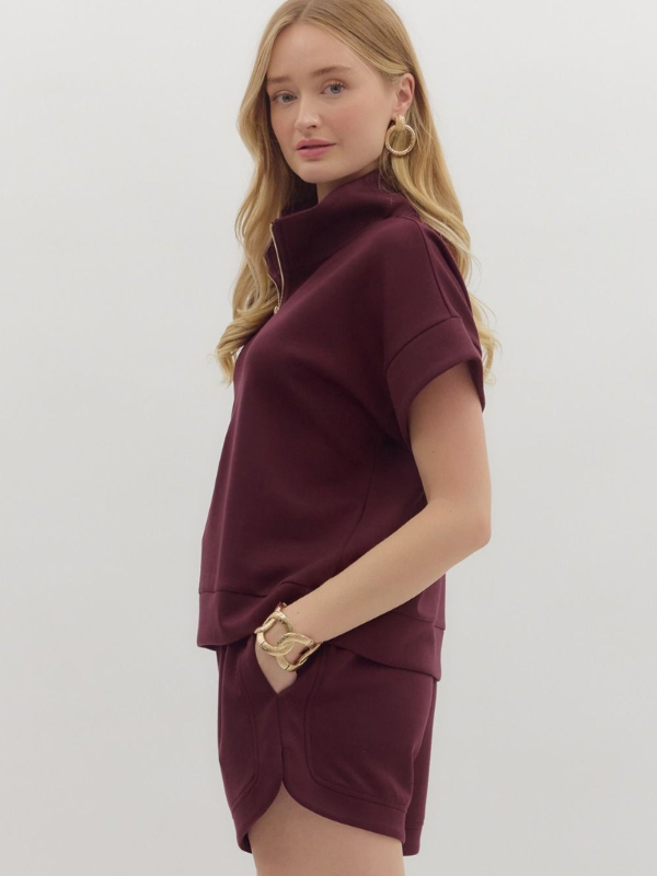 Woman wearing a burgundy dress with a plain background