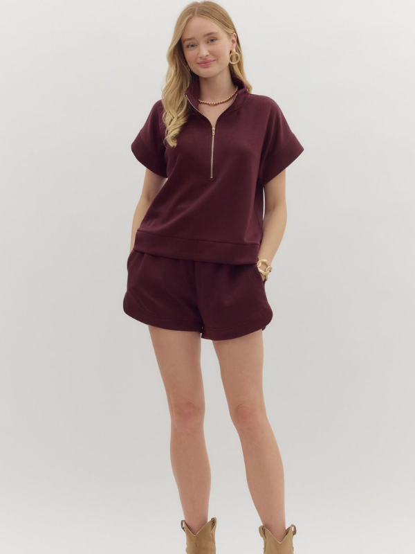 Woman wearing a burgundy outfit with a white background