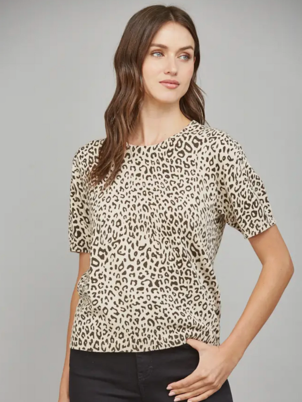 Woman wearing a leopard print top against a gray background