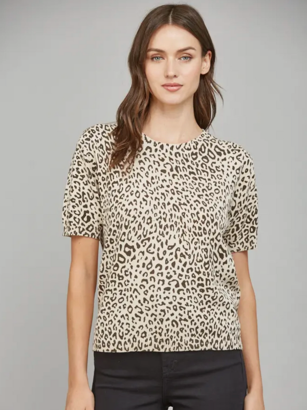 Woman wearing a leopard print top against a gray background